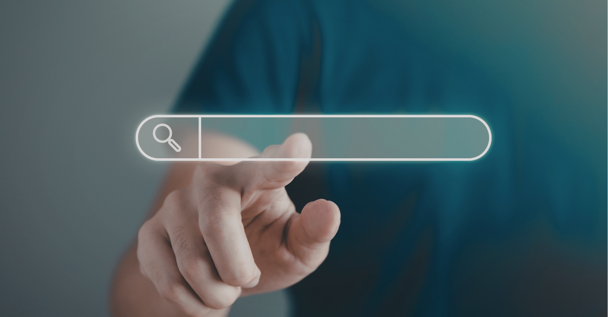 Slightly blurred image of a finger about to tap on a large search bar. 